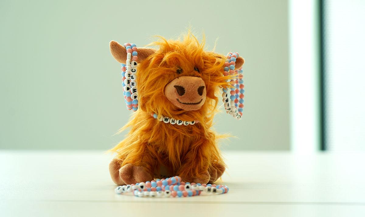 Cow soft toy with bracelets hanging from its horns