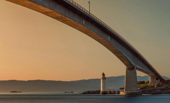 View of underside of bridge crossing body of water in Scottish Highlands.